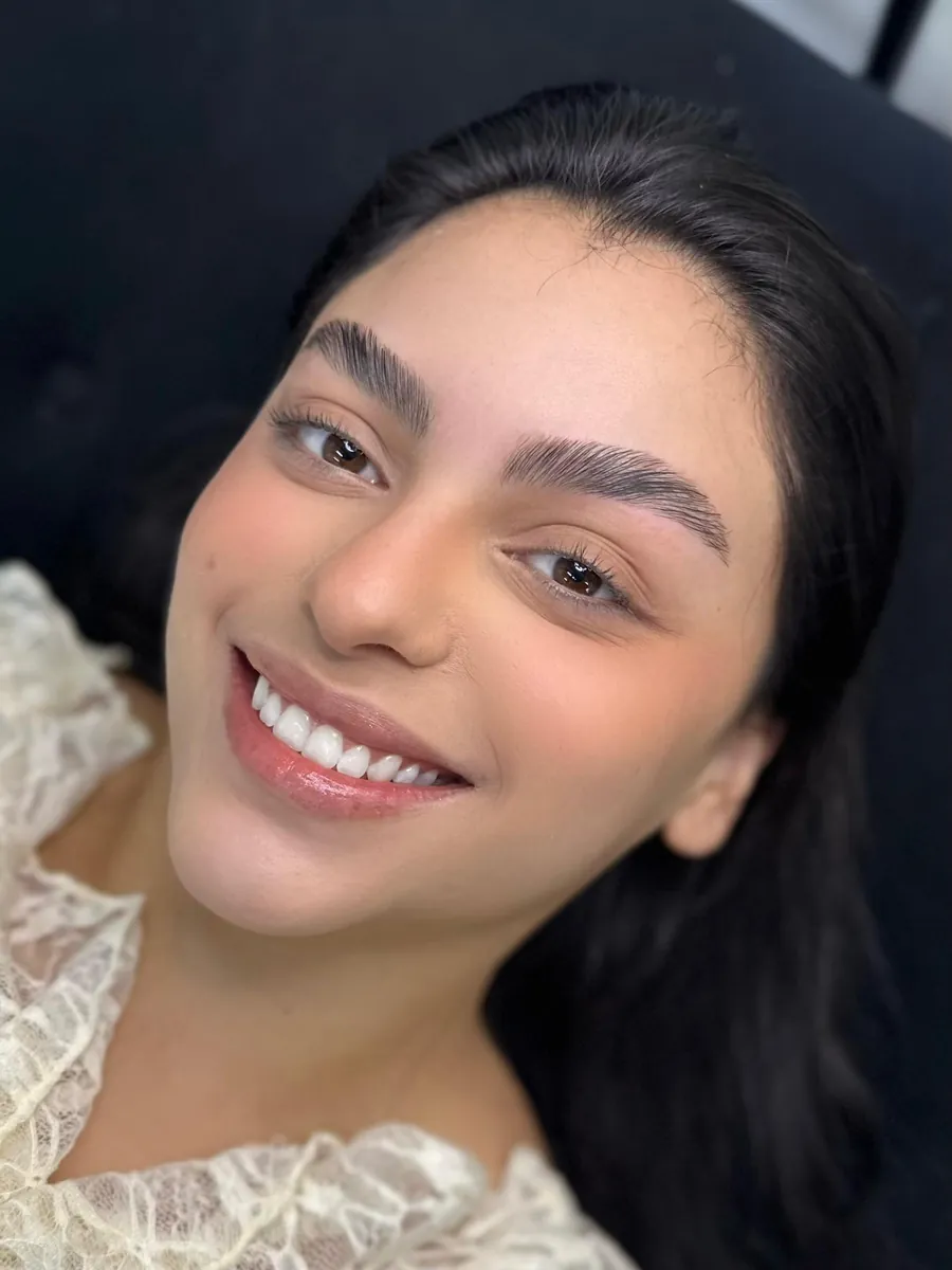 Sobrancelhas com fios alinhados e definidos, cliente sorrindo