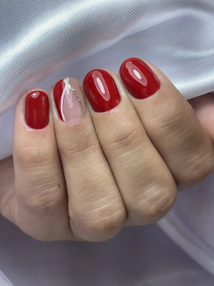 Unhas vermelhas com nail art em uma unha